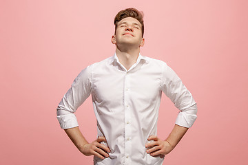 Image showing The happy business man standing and smiling against pink background.