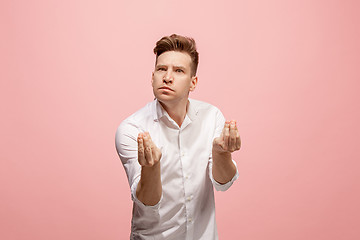 Image showing Beautiful male half-length portrait isolated on pink studio backgroud. The young emotional surprised man