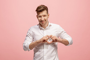 Image showing The happy business man standing and smiling against pink background.