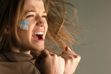 Image showing Portrait of a woman with the flag of the Argentina painted on her face.