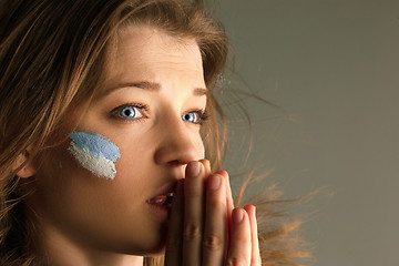 Image showing Portrait of a woman with the flag of the Argentina painted on her face.