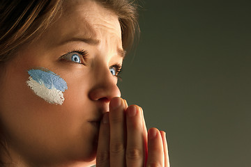 Image showing Portrait of a woman with the flag of the Argentina painted on her face.