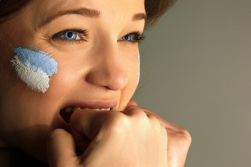 Image showing Portrait of a woman with the flag of the Argentina painted on her face.