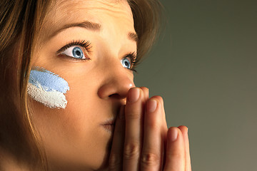 Image showing Portrait of a woman with the flag of the Argentina painted on her face.