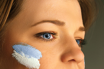 Image showing Portrait of a woman with the flag of the Argentina painted on her face.