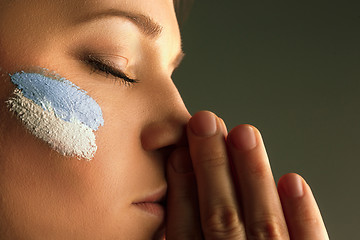 Image showing Portrait of a woman with the flag of the Argentina painted on her face.