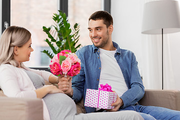 Image showing man giving flowers to pregnant woman at home