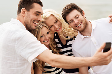 Image showing happy friends taking selfie on summer beach