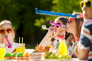Image showing kids blowing party horns on birthday in summer