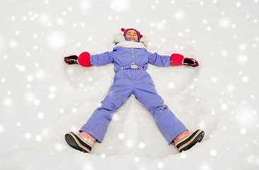 Image showing happy little girl making snow angels in winter