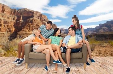 Image showing friends sitting on sofa over grand canyon