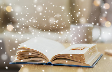 Image showing book with autumn leaf on table over snow