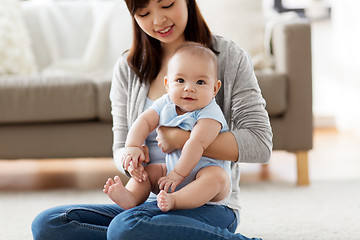 Image showing happy young mother with little baby at home