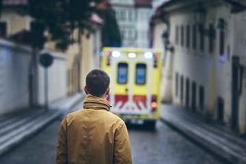 Image showing Man looking at leaving ambulance car