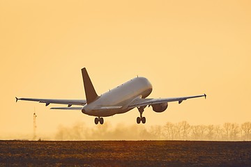 Image showing Airplane taking off at sunset