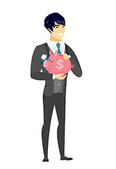 Image showing Asian groom holding a piggy bank.