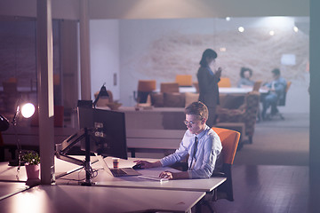 Image showing man working on computer in dark office