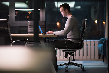 Image showing man working on laptop in dark office