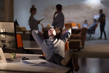 Image showing businessman sitting with legs on desk at office