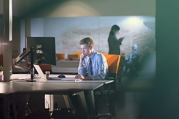 Image showing man working on computer in dark office