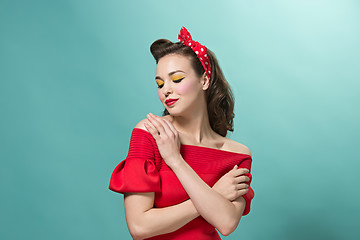 Image showing Beautiful young woman with pinup make-up and hairstyle. Studio shot on white background