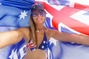 Image showing Proudly Australian - Cheerful woman with Australian Flag