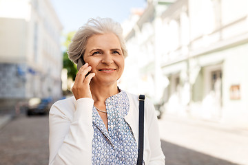 Image showing senior woman calling on smartphone in city