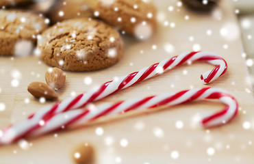 Image showing candy canes, cookies and almonds on board