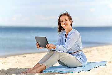 Image showing happy smiling woman with tablet pc on summer beach