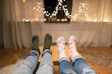 Image showing close up of couple feet and garland lights at home