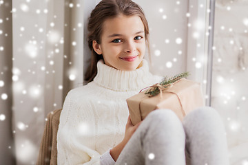 Image showing girl with christmas gift sitting at home