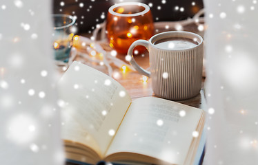 Image showing book and cup of coffee or hot chocolate over snow