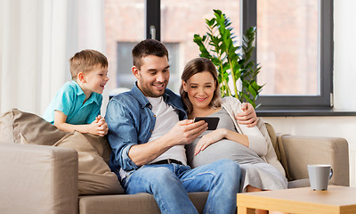 Image showing happy family with smartphone at home