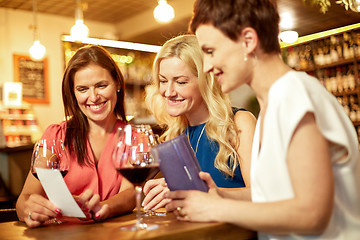 Image showing women looking at bill at wine bar or restaurant