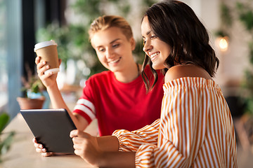 Image showing female friends with tablet pc and coffee at cafe