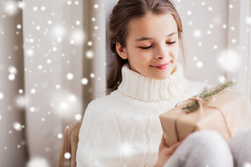 Image showing girl with christmas gift sitting at home