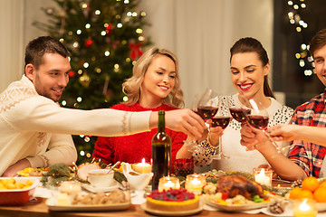 Image showing happy friends drinking red wine at christmas party