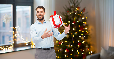 Image showing happy man with christmas gift at home