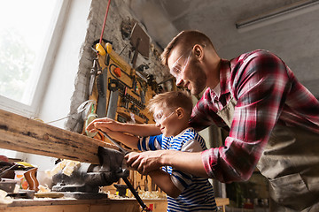 Image showing father and son with rasp working at workshop