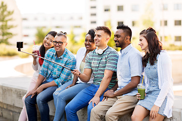 Image showing friends taking picture by on selfie stick in city