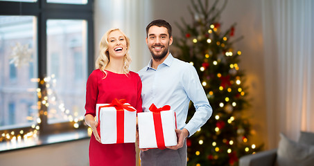 Image showing happy couple with christmas gifts at home