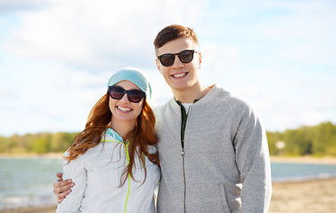 Image showing happy teenage couple over beach background