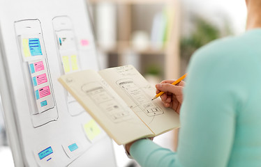 Image showing ui designer with user interface sketch in notebook