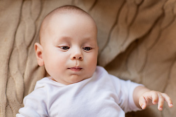 Image showing sweet little baby boy lying on knitted blanket