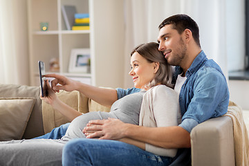 Image showing man and pregnant woman with tablet pc at home
