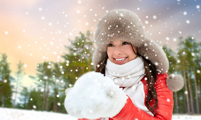 Image showing woman in fur hat with snow over winter forest