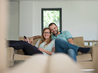 Image showing Young couple on the sofa watching television