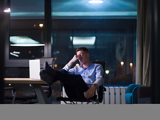 Image showing businessman sitting with legs on desk at office