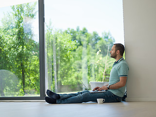 Image showing man drinking coffee on the floor enjoying relaxing lifestyle