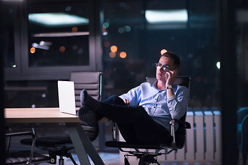 Image showing businessman using mobile phone in dark office